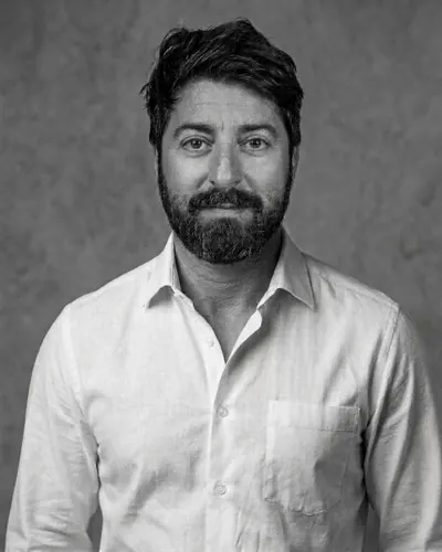 Retrato en blanco y negro de Mario Amadeo Muñoz Castellano, fundador de dbricks, con camisa blanca